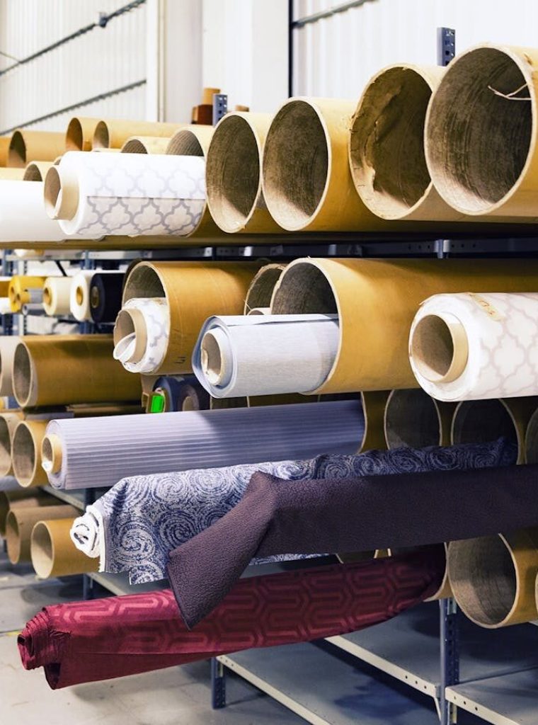Rows of textile rolls stored in a factory for industrial manufacturing.